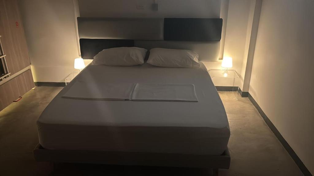 Una cama en una habitación con dos luces. en Don Hostel, en Villavicencio