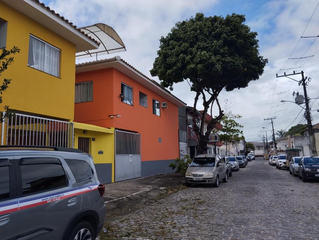 a street with cars parked next to a building at Condomínio Il Sole - apartamento 1 in Porto Seguro