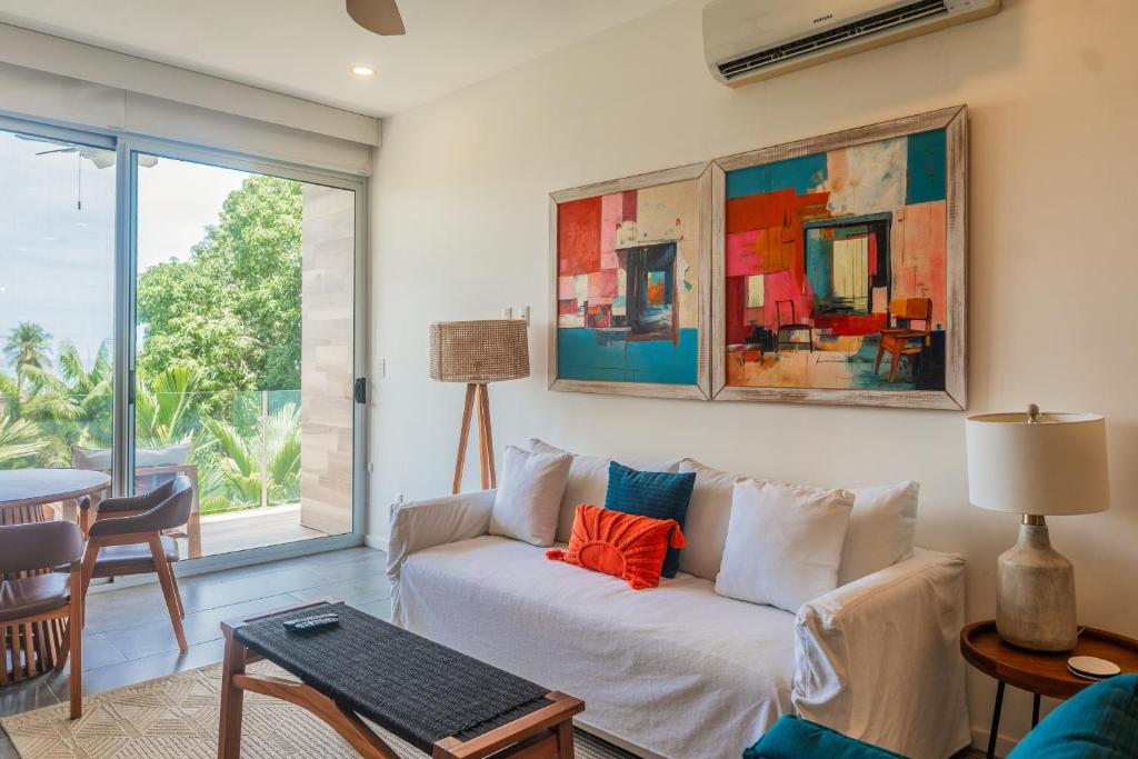 a living room with a couch and a large window at Sunset Boulevard 304 in Pochotal