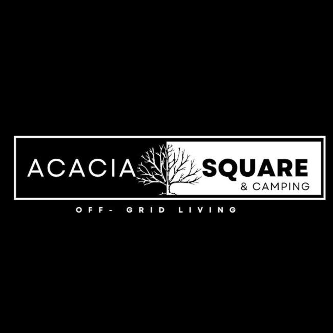 a white sign with a tree on it at Acacia Square & Camping in Kitengela 