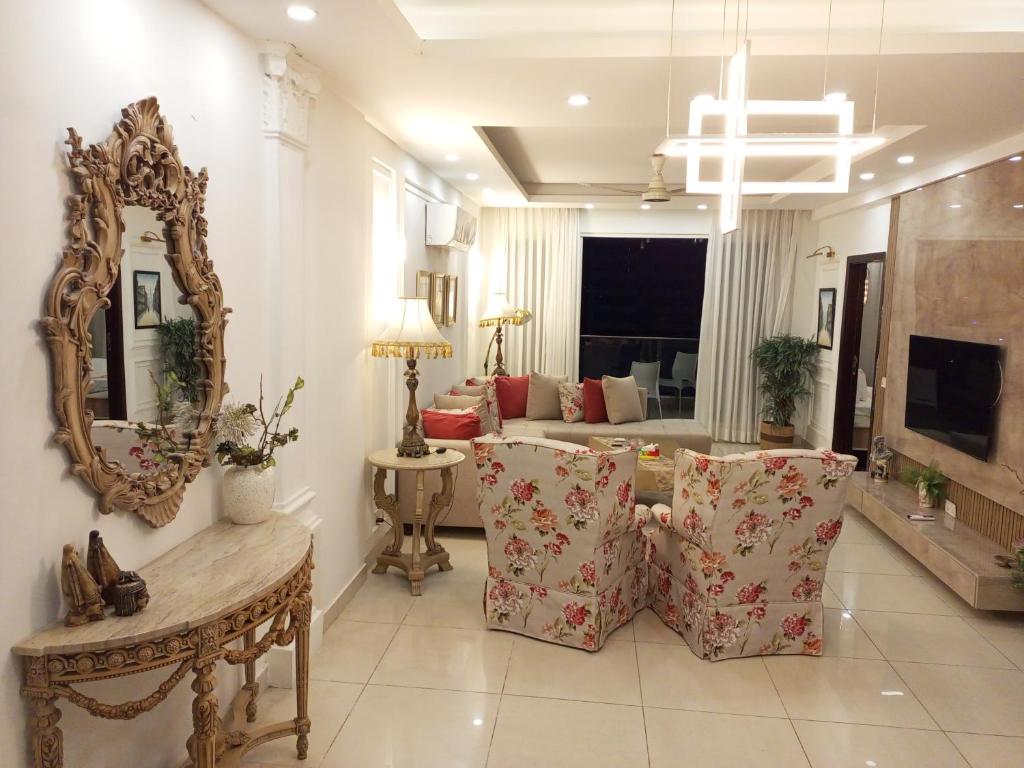 ein Wohnzimmer mit Sofa und Spiegel in der Unterkunft Said's Suites Elysium Tower Opposite to Centaurus Mall in Islamabad