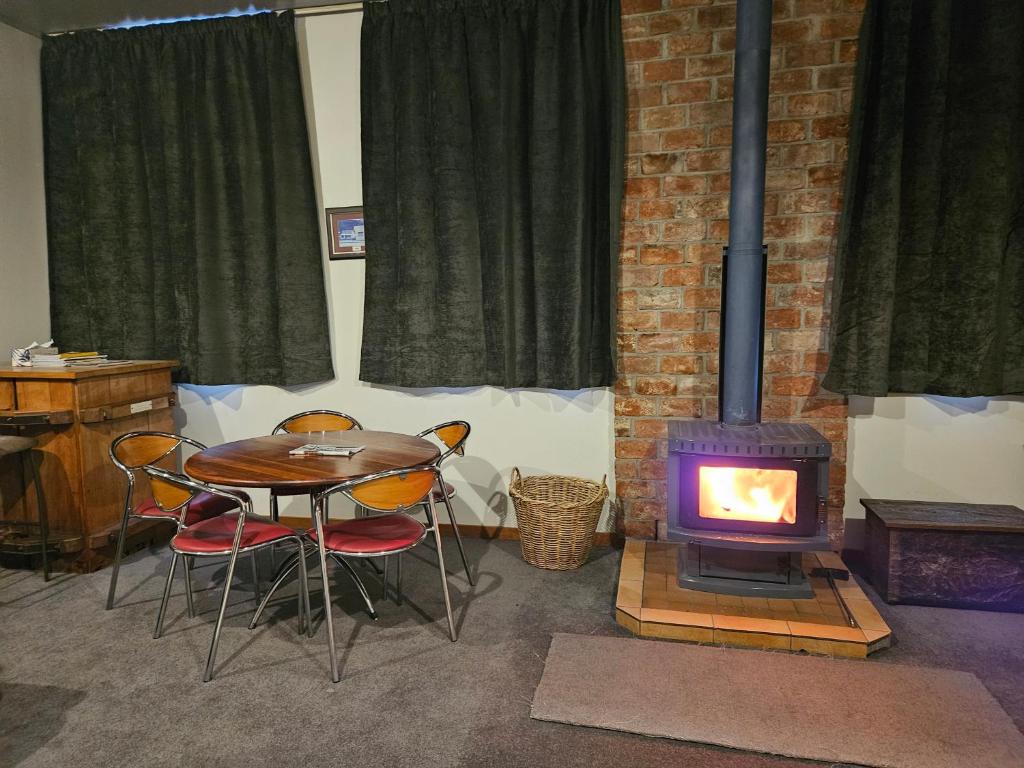 Cette chambre dispose d'une table et d'un poêle à bois. dans l'établissement Friends & Family Groups gather, à Roxburgh
