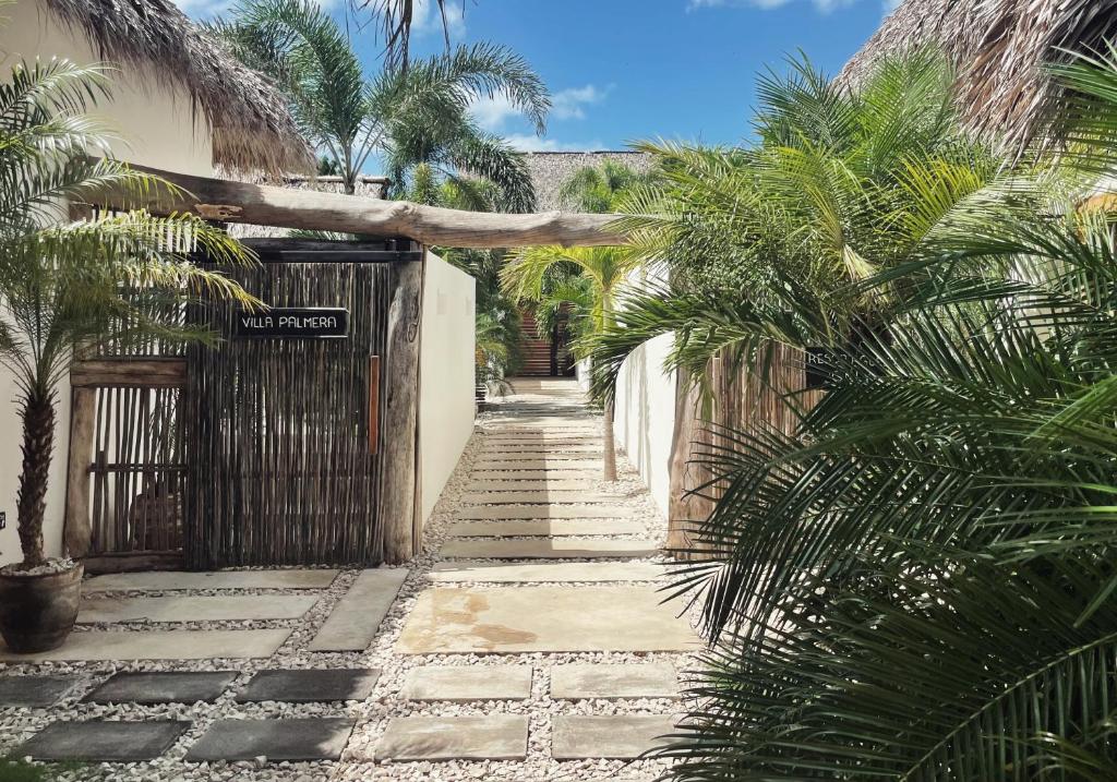 une allée avec des palmiers devant une maison dans l'établissement Mahalo Boutique B&B, à Popoyo