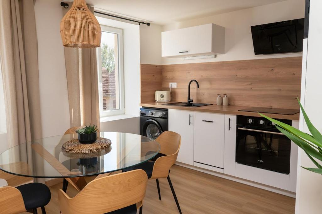 a kitchen with a glass table and a dining room at Le Yucca Apartment, Nature Stay in Oberhaslach