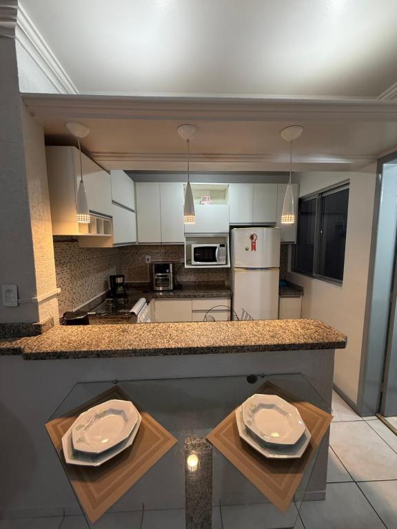 a kitchen with a counter with two plates on it at Apartamento no centro in Foz do Iguaçu