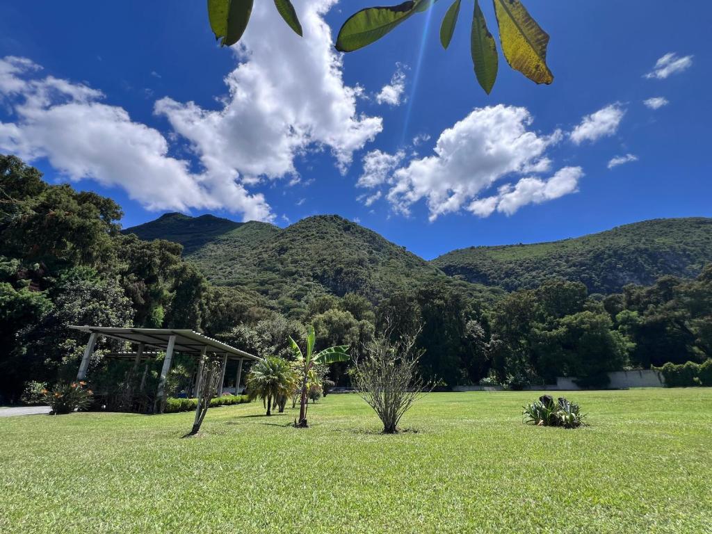 un champ herbeux avec des montagnes en arrière-plan dans l'établissement Chalet 1 hectárea junto al río y montaña a 20 min de Orizaba, à Nogales