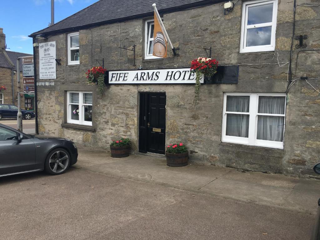 a car parked in front of a stone building at The Fife Arms Hotel in Keith