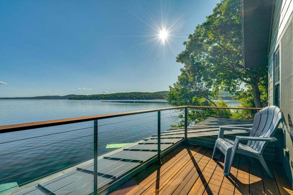 a balcony with a chair and a view of the water at Ice Fishing and Scenic Views! Lake Bomoseen Retreat in Bomoseen