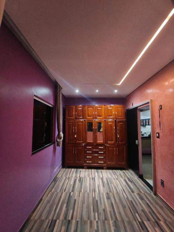 a room with purple walls and wooden cabinets at Casa completa in Marituba