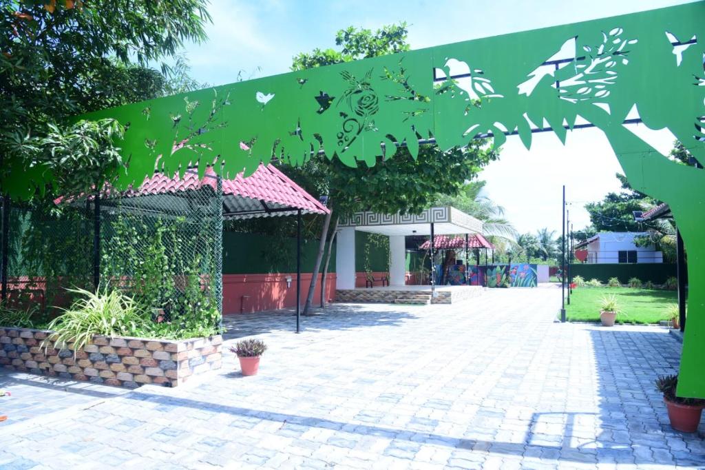 un pavillon dans une école avec un panneau vert dans l'établissement Royal gardens party Hall, à Wālājāpet