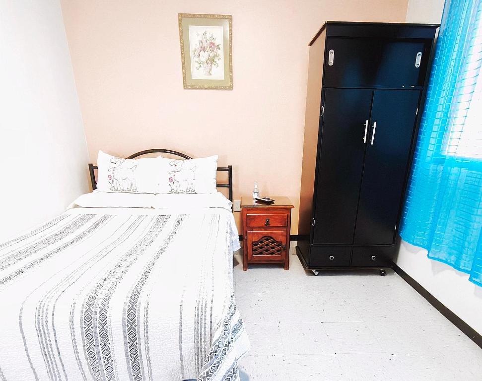 a bedroom with a bed and a black cabinet at Nice bedroom at 5 min Mexico City Airport T1 & T2 in Mexico City