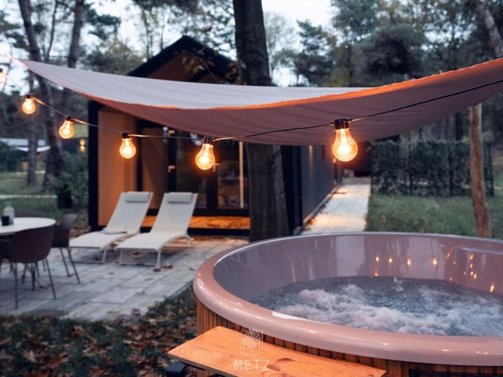a large hot tub with a canopy over a patio at Wellness Lodge with Hottub Haarle in Haarle