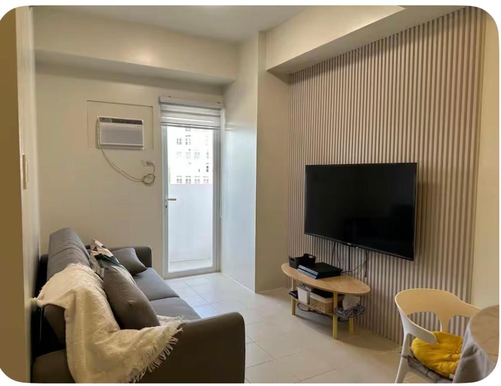Biñanにある1Bedroom, living room w balcony ADHI staycationのソファと薄型テレビのあるリビングルーム