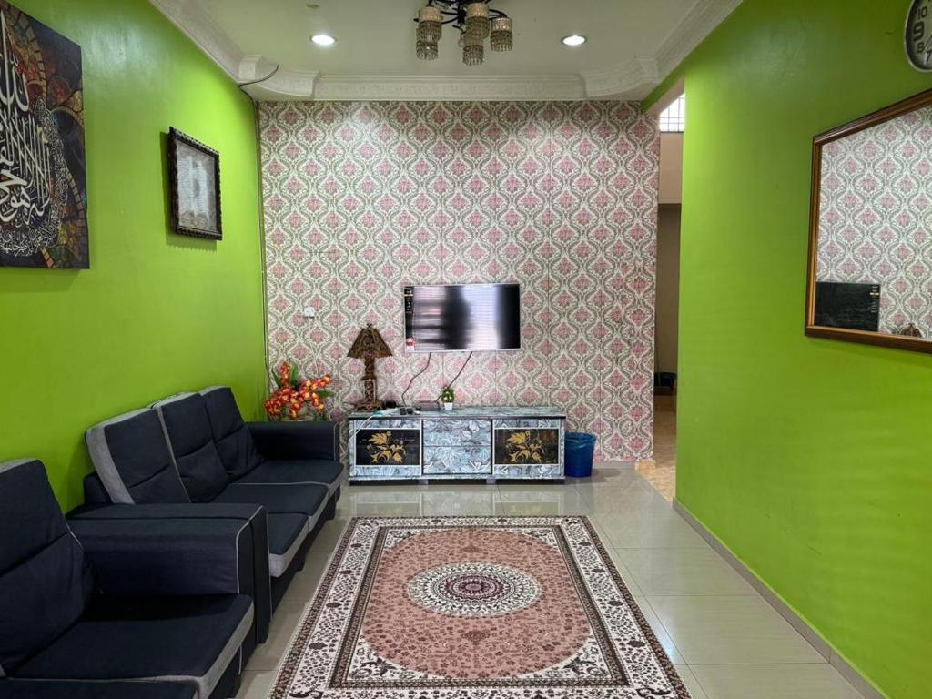 a green living room with a couch and a tv at Labis Homestay Afina in Labis