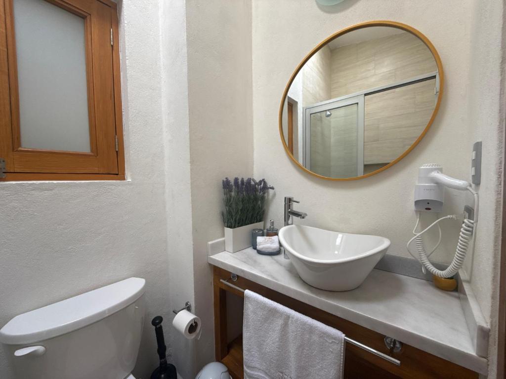 een badkamer met een wastafel en een spiegel bij Sicilia con Terraza y chimenea in Santeagueda