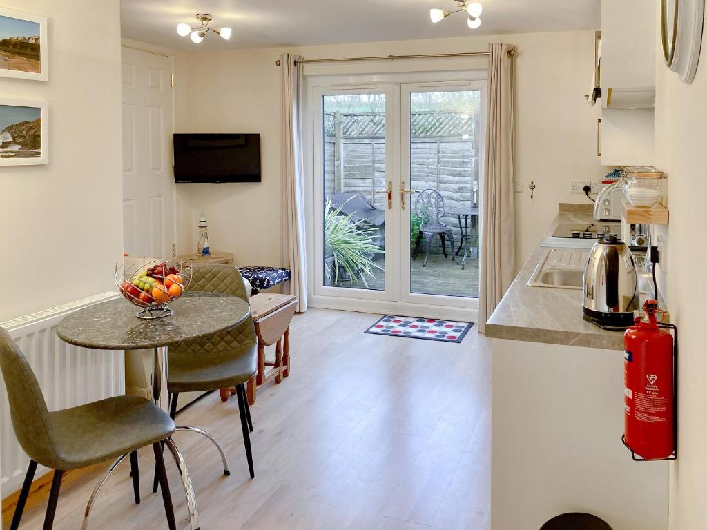 a kitchen with a table with a bowl of fruit on it at The Honeypot in Padstow