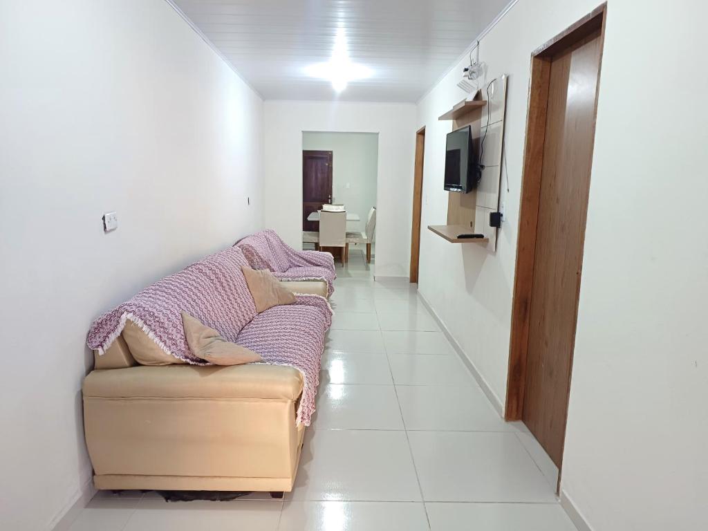 a living room with a couch and a television at Casa no centro de Japaratinga in Japaratinga