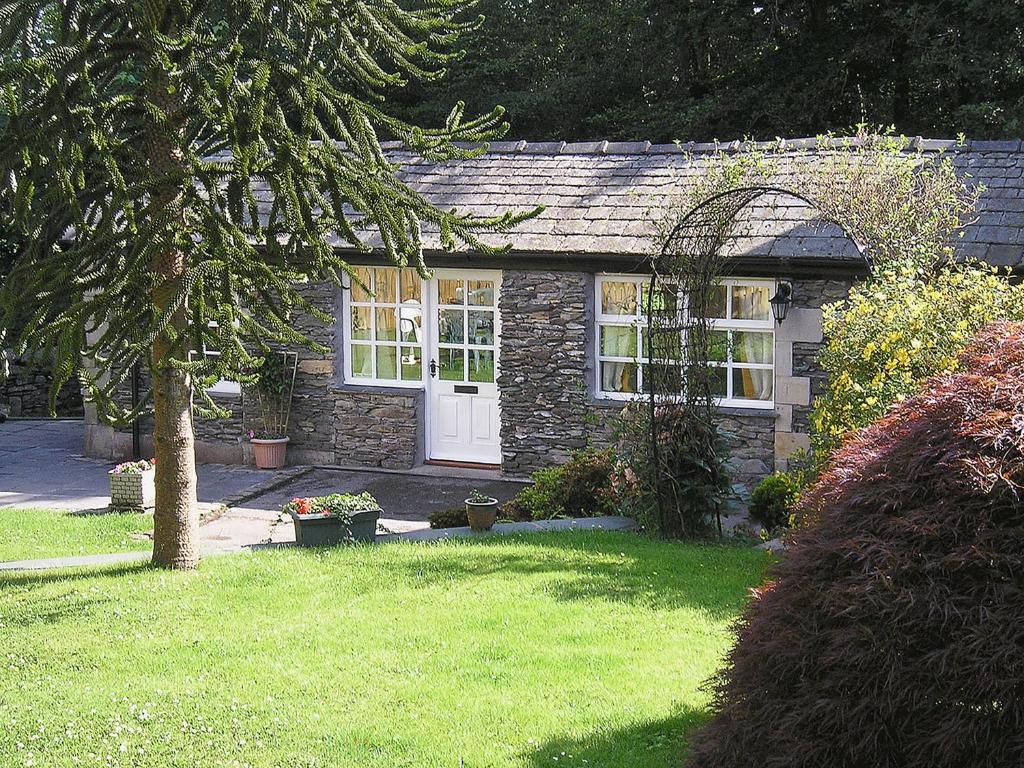 a small stone house with a white door at The Farriers - 26967 in Windermere