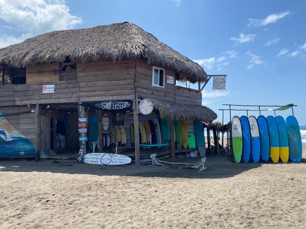 a shack with surfboards in front of it on the beach at Buena Onda Surf House in León