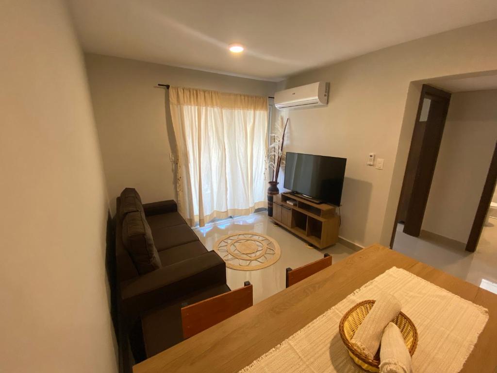 un soggiorno con un divano e una televisione di Encantador apartamento de 2 dormitorios a Luque