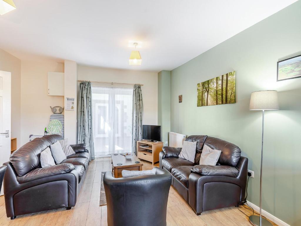 un salon avec deux canapés en cuir et une télévision dans l'établissement Snowdrop Cottage - W43121, à Goxhill