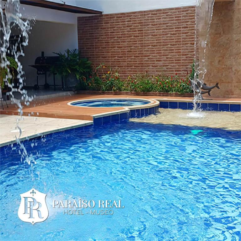 a pool with two fountains in a backyard at Paraíso Real in Buga