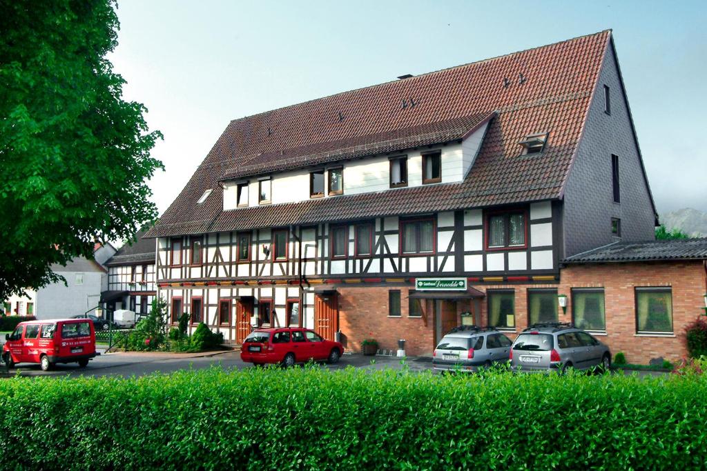 een groot gebouw met auto's geparkeerd voor het bij Gasthaus Dernedde in Osterode