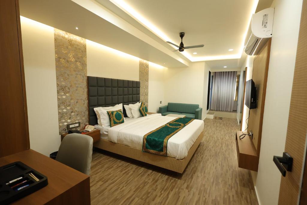 una habitación de hotel con una cama y un televisor en Hotel Heaven Blue, en Rajkot