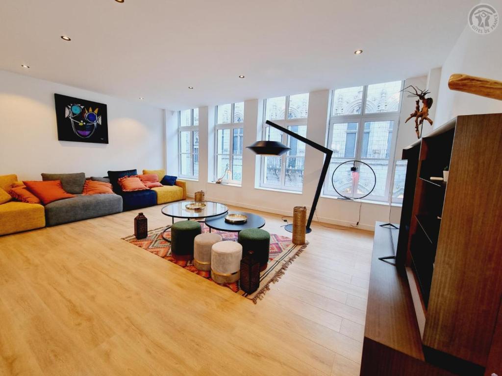 a living room with a couch and a table at Appartement haut standing au cœur de Douai avec wifi, climatisation et terrasse - FR-1-510-235 in Douai