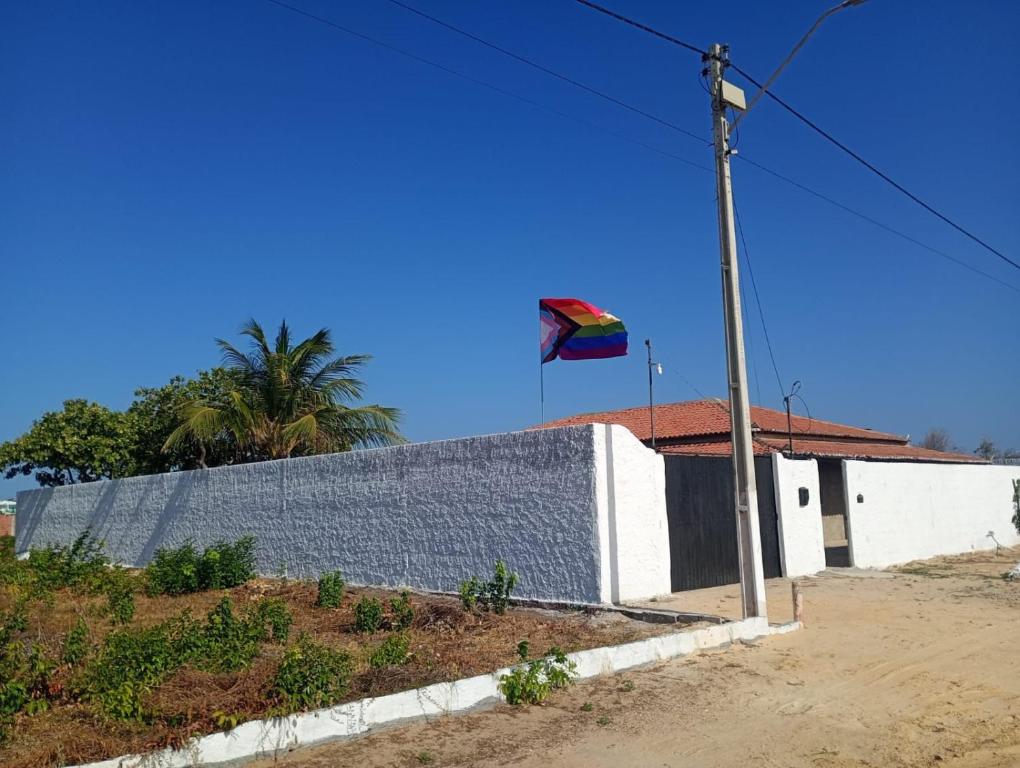 a kite flying in the sky next to a building at Pensionado Mami Tchesca in Aracati