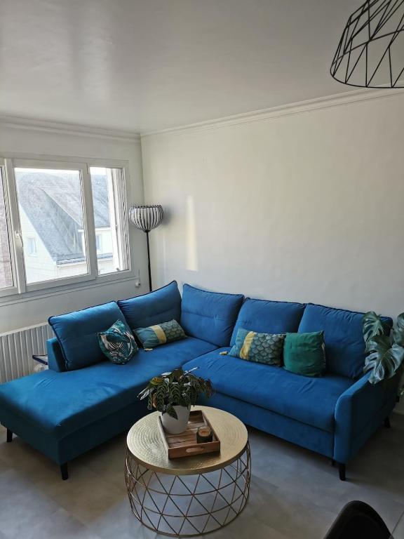 a blue couch in a living room with a table at Superb apartment near RER A free parking in Boissy-Saint-Léger