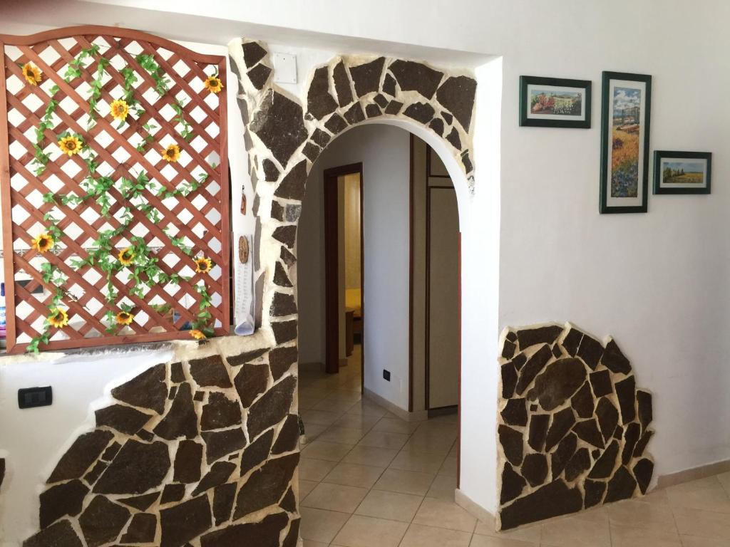 a hallway with a stone wall and an archway at Sacca House in Reggio di Calabria