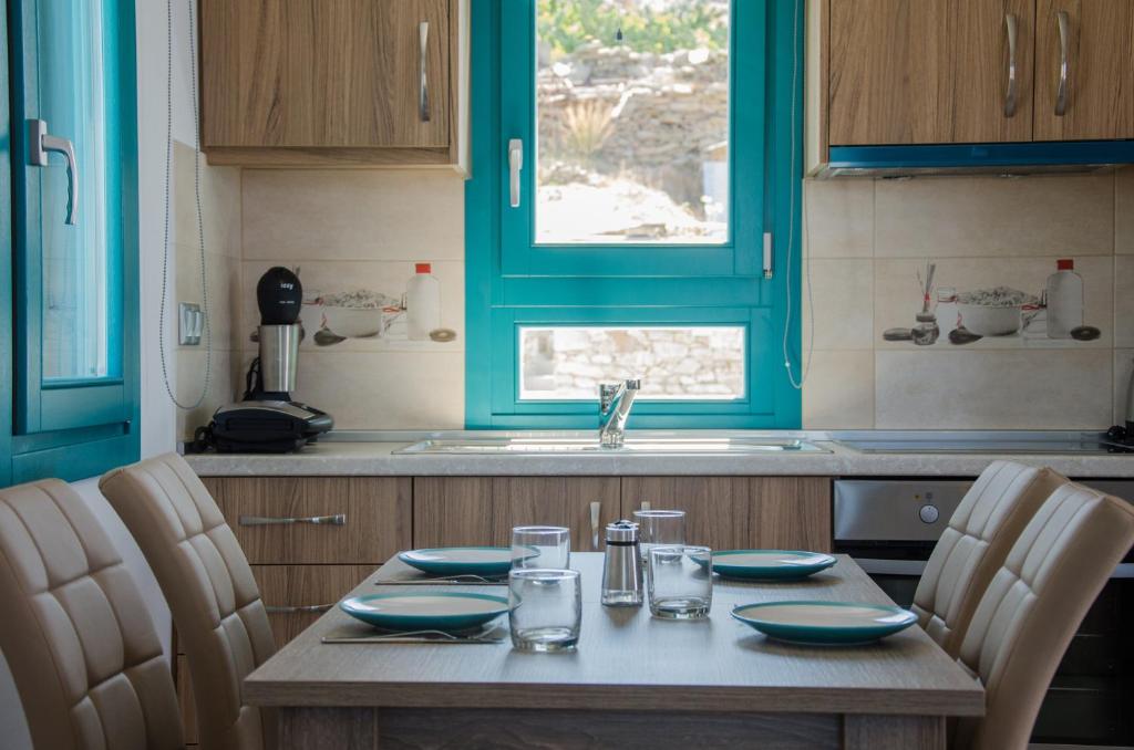 a table in a kitchen with blue cabinets and a sink at Ios Sea View in Ios Chora