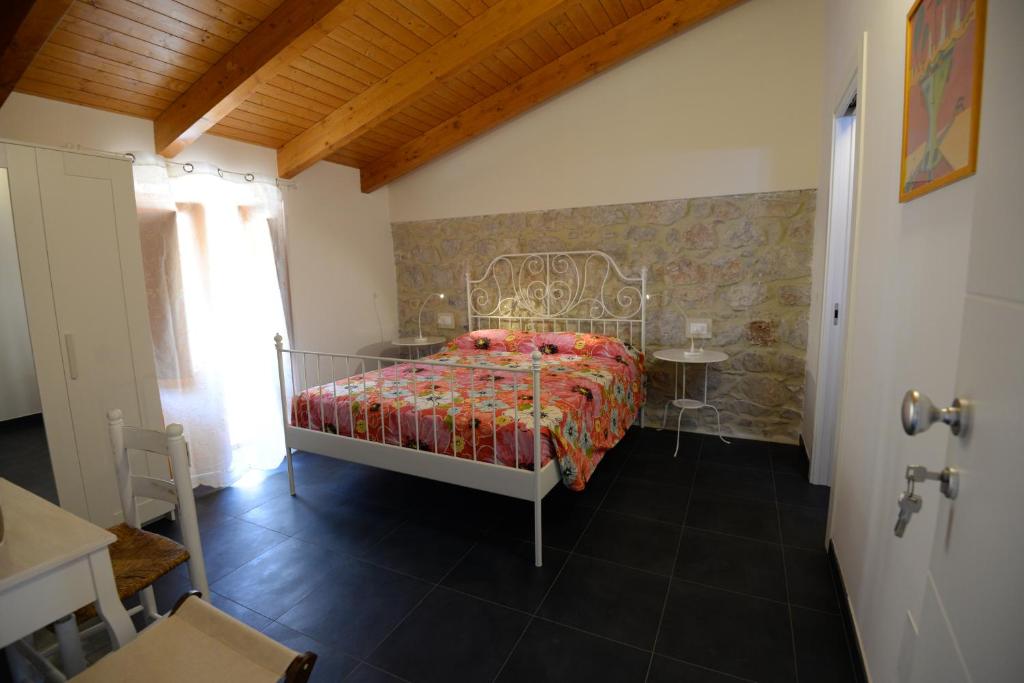 um quarto com uma cama e uma parede de pedra em Al Giardino di Anna em Fondi