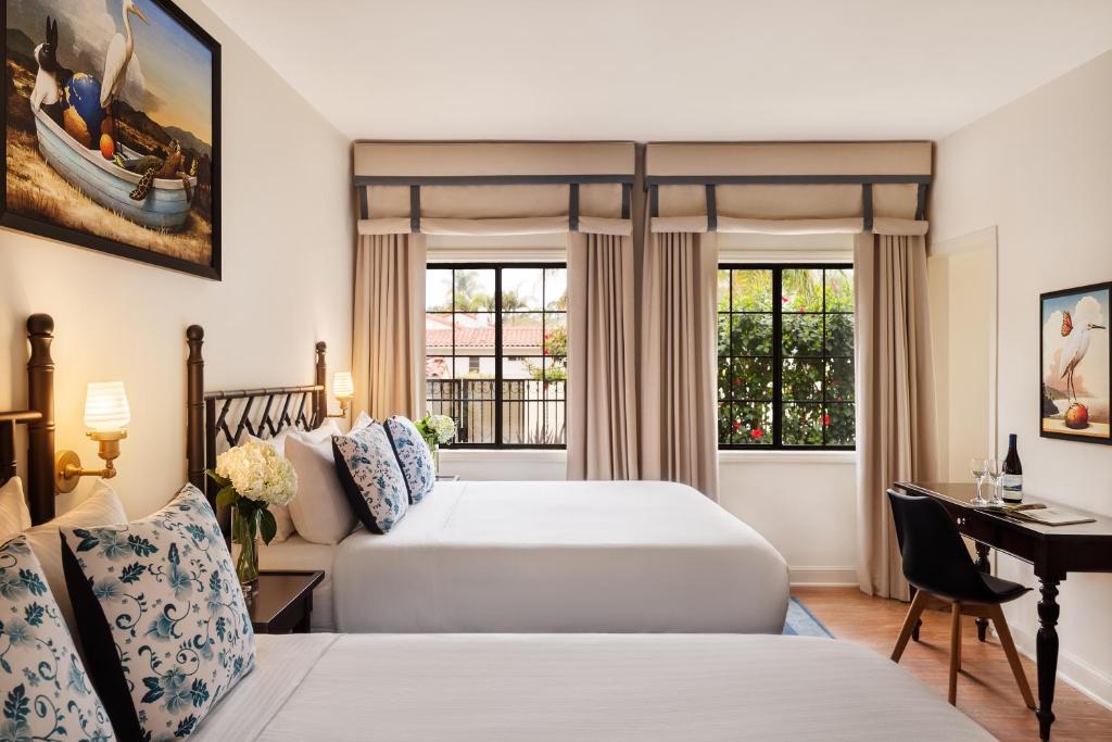 a hotel room with two beds and a desk at The Milo in Santa Barbara