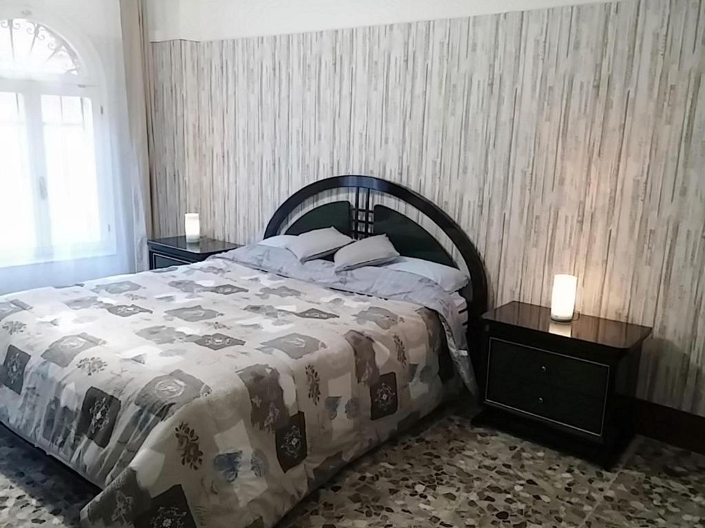 ein Schlafzimmer mit einem großen Bett und zwei Nachttischen in der Unterkunft Casa sul rio in Venedig