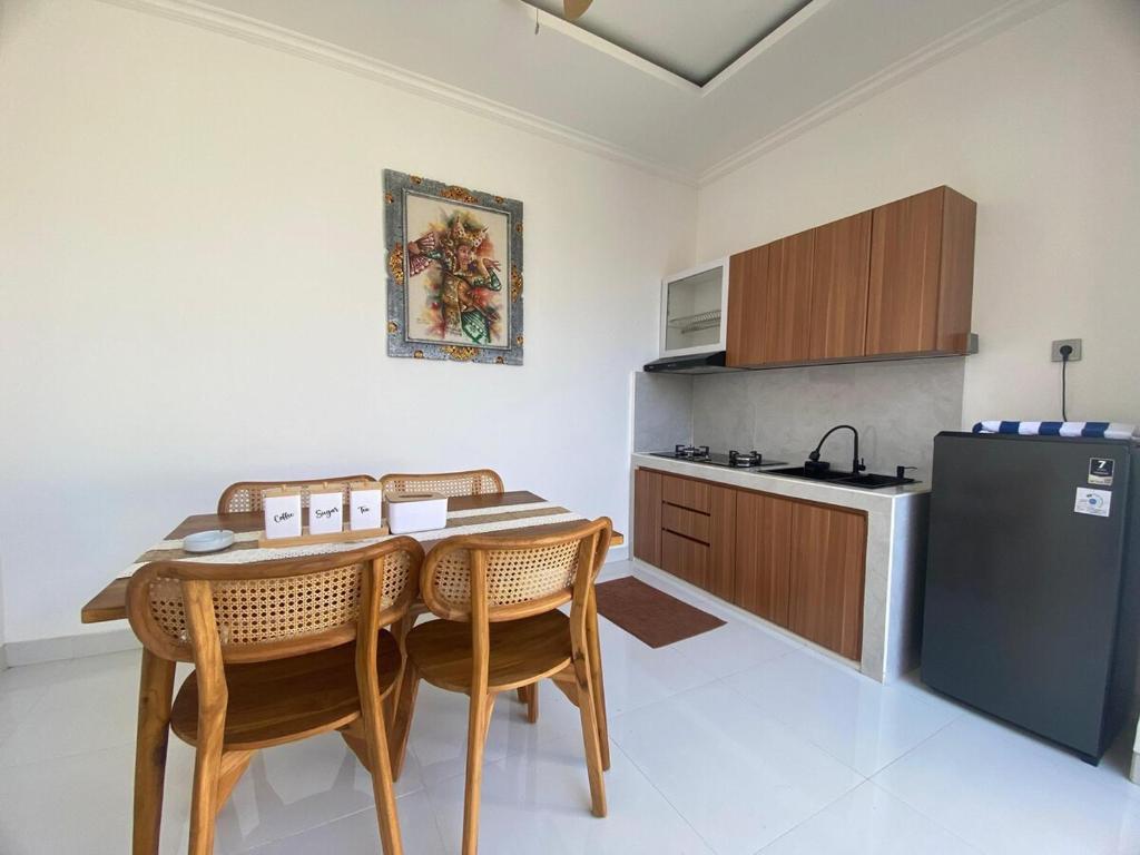 a kitchen with a table and chairs and a refrigerator at Villa Bulan by MentariPro Bali in Singaraja