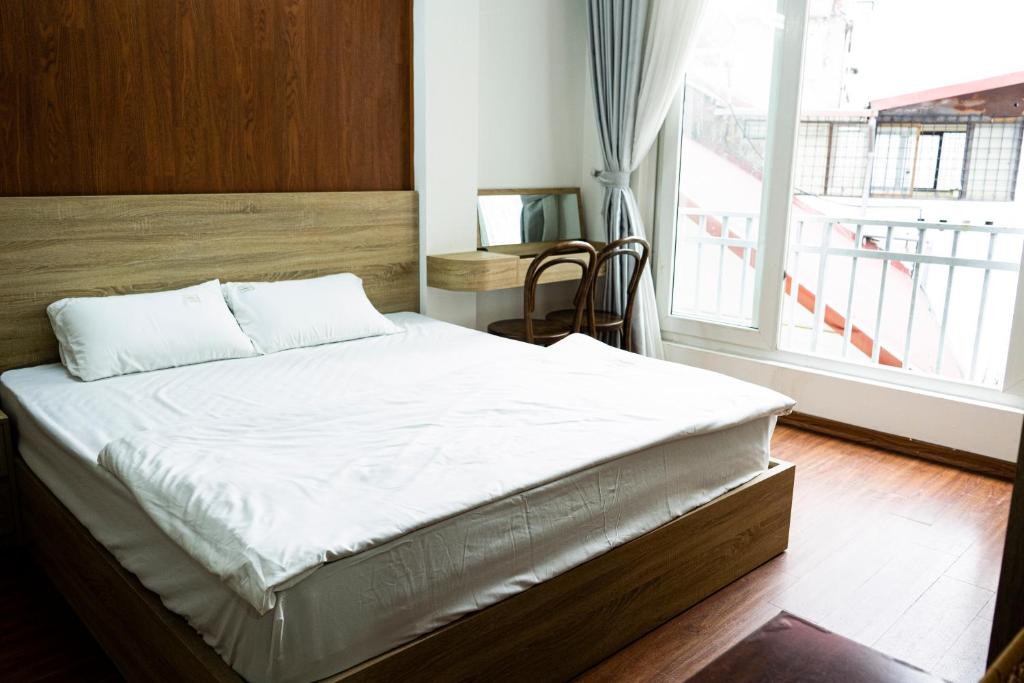 ein großes Bett in einem Zimmer mit einem großen Fenster in der Unterkunft Big Church Homestay in Hanoi