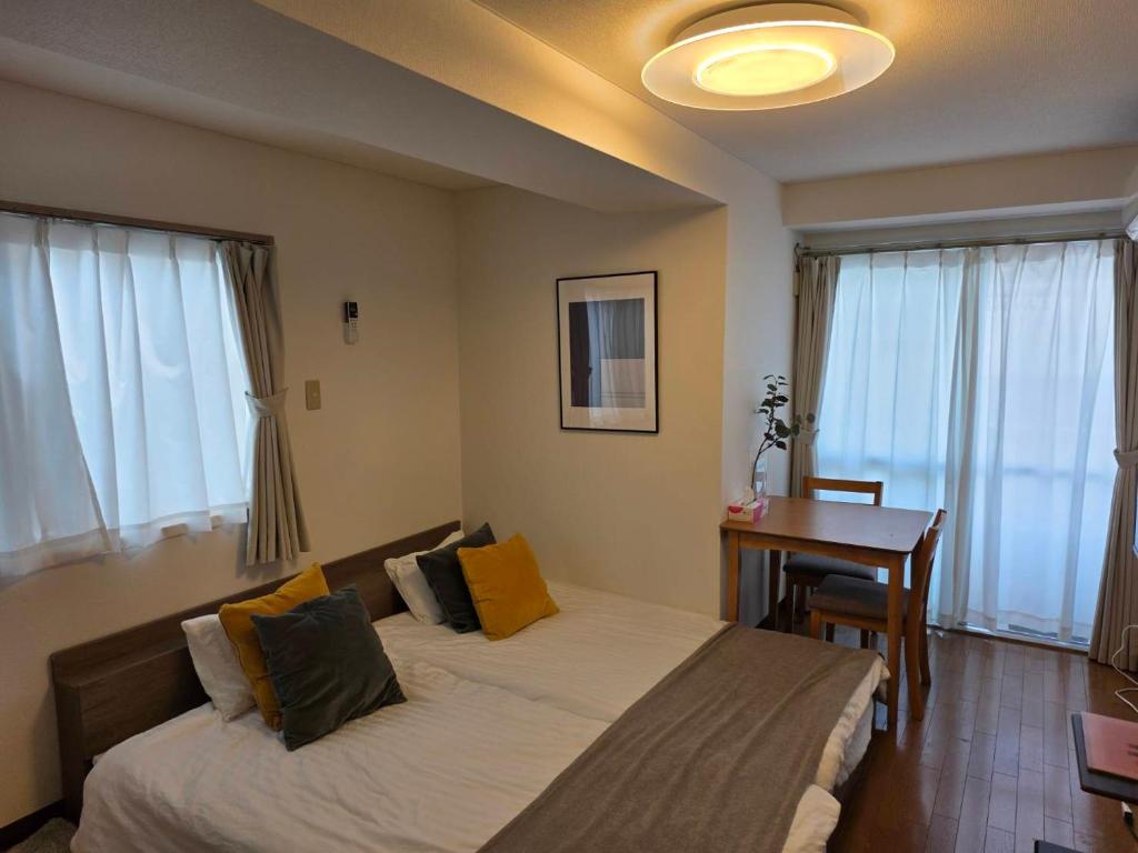 東京にあるホテルレスポワール301のベッドルーム1室(ベッド2台、デスク、窓付)