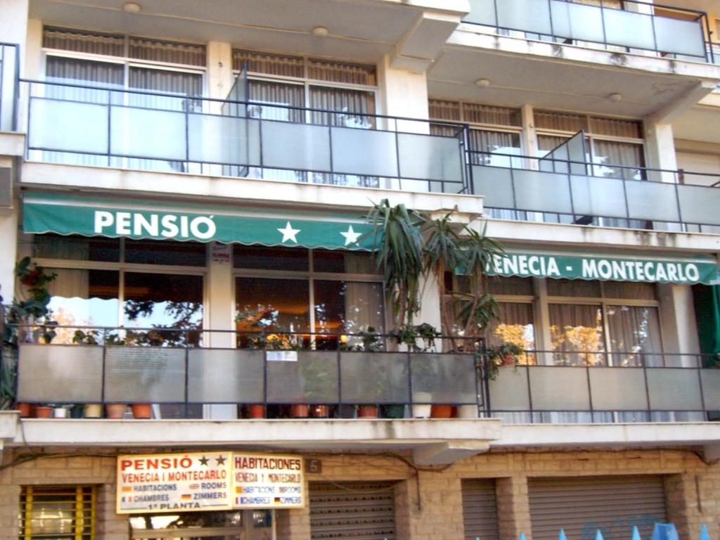 an apartment building with a balcony and a restaurant at Pensión Venecia in Salou