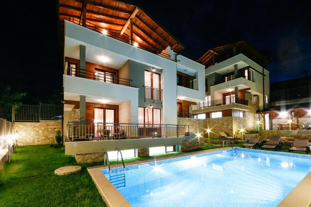 a villa with a swimming pool at night at Twin House in Ognyanovo