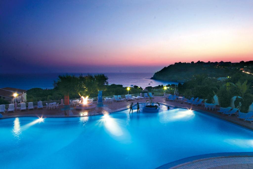 a view of a swimming pool at night at Residence Villaggio Smedile in Capo Vaticano
