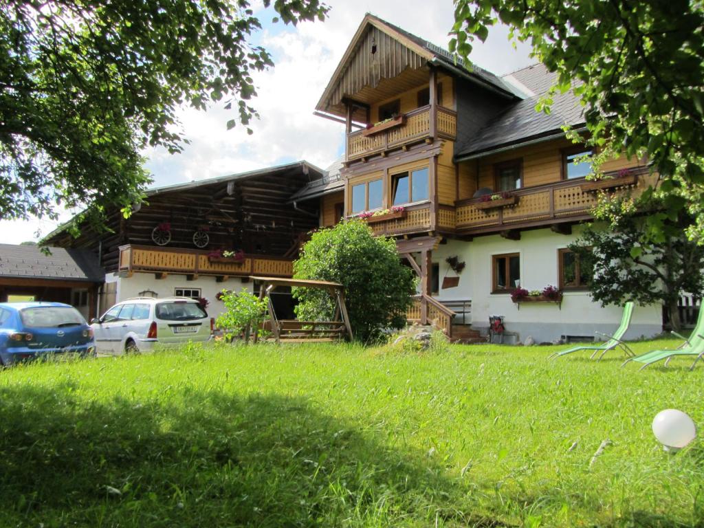 ein Haus mit Rasen davor in der Unterkunft Obergrabnerhof in Ramsau am Dachstein