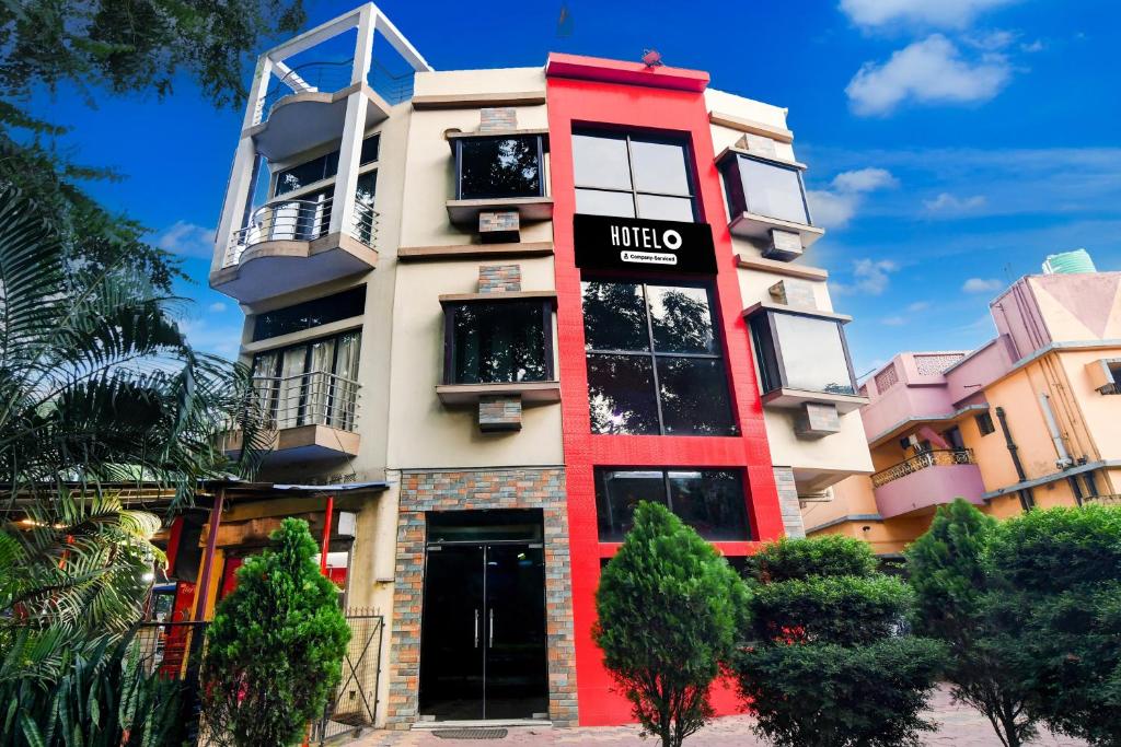 a tall red building with a sign on it at Super Hotel O NIT Durgapur Formerly Royal Inn in Durgāpur
