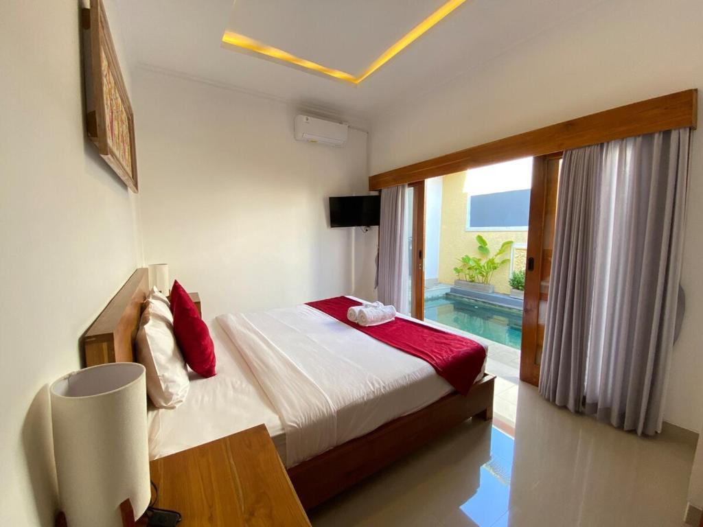 Un dormitorio con una cama y vistas a una piscina. en Villa Vina by MentariPro Bali, en Singaraja