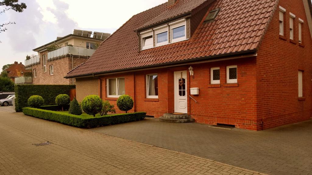 uma casa de tijolos vermelhos com uma porta branca numa rua em An der Wilhelmshöhe em Lingen