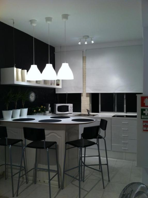 a kitchen with a island with bar stools at In Bed with Lisbon 7D in Amadora