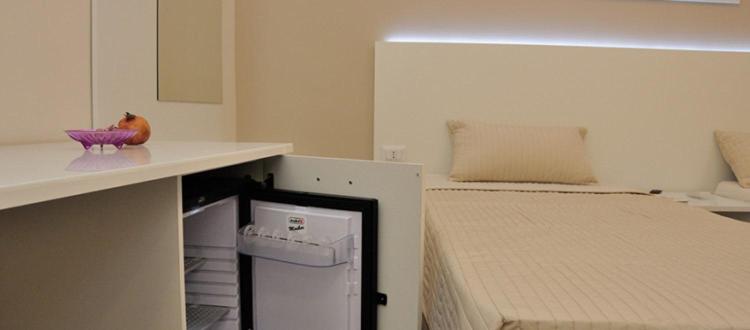 グラヴィーナ・イン・プーリアにあるIl Piccolo Principe B&Bのベッド1台、カウンター(シンク付)が備わる小さな客室です。