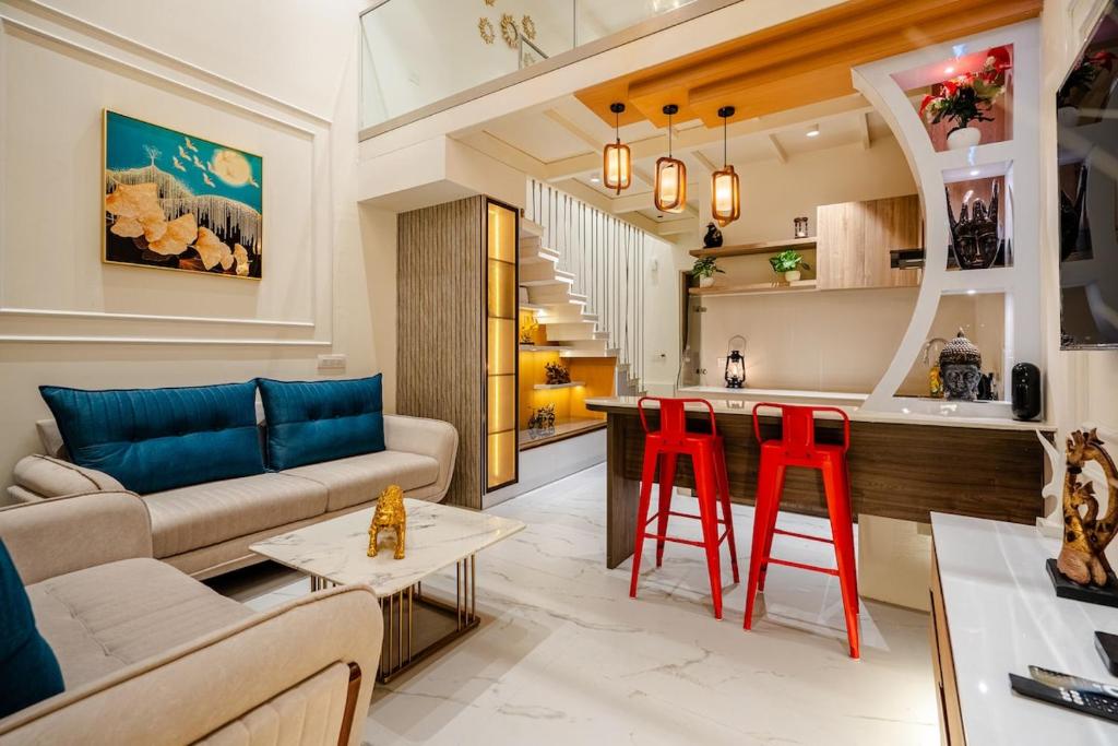 a living room with a couch and red bar stools at Modern Duplex Retreat in Sec 71 in Gurgaon