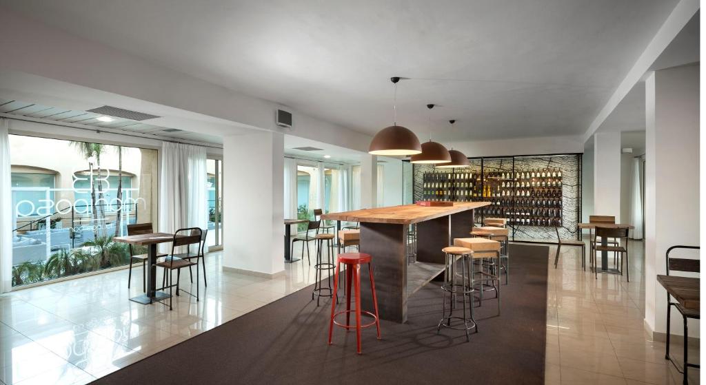 a kitchen with a bar and some stools at Hotel San Teodoro in San Teodoro